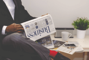Man reading a business newspaper with financial data